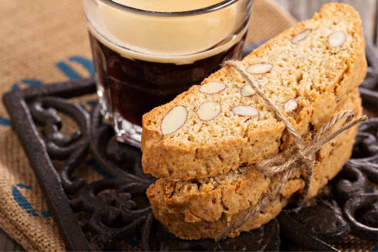 A stack of 3 keto biscotti and a cup of black coffee. 