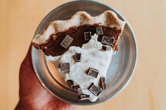 Slice of low-carb French silk pie topped with whipped cream and chocolate shavings.