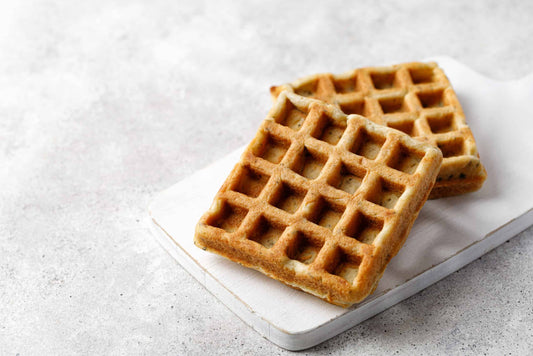 Two keto chaffles stacked on a plate showing the crisp waffle texture.