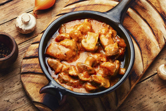 Low-carb sausage stroganoff with mushrooms and peppers in a cast iron pan.