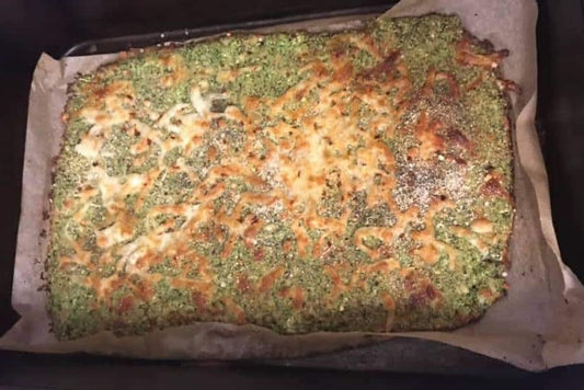 Low-carb broccoli cheesy bread cut into strips on a wooden board.