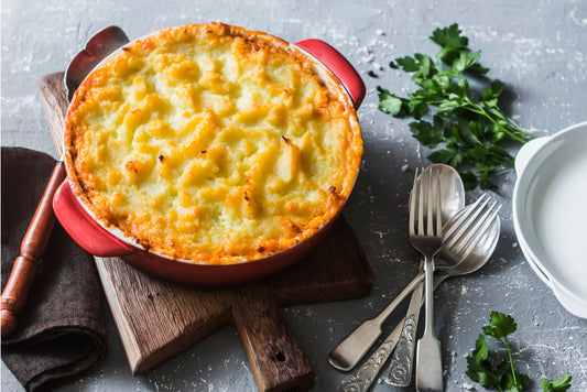 Low-carb shepherd's pie with a golden cauliflower mash topping in a white baking dish.