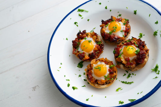 Low-carb corned beef egg cups baked in a muffin tin with spinach visible.