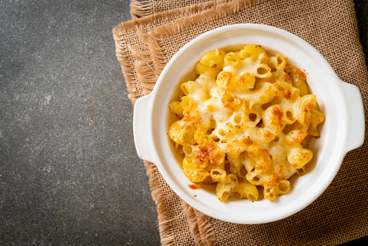 Low-carb mac and cheese in a white ceramic bowl on a black kitchen counter.