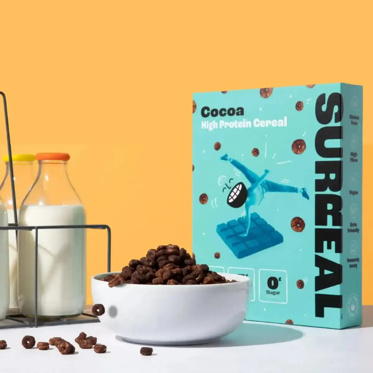 Surreal Cocoa High Protein Cereal box with chocolate hoops and milk bottles on a vibrant orange background.