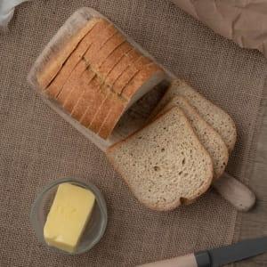 Artisan baked goods: golden loaves of seeded bread and rolls on burlap.
