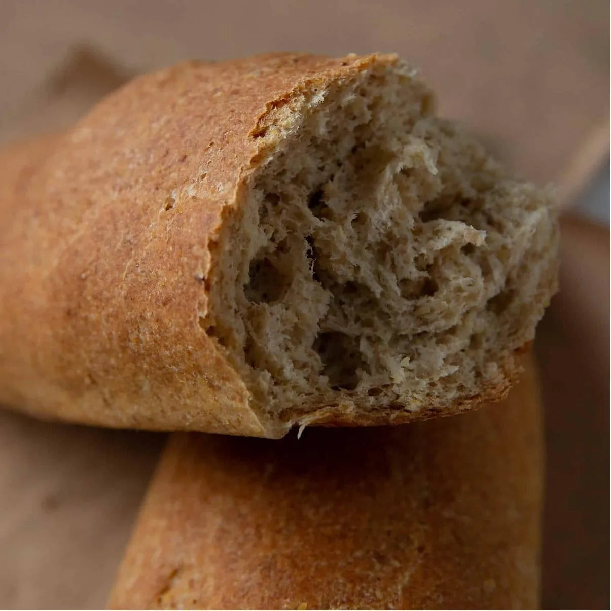 Golden-brown keto baguette, torn open to reveal its soft, airy texture.